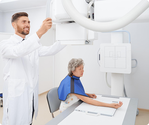 Technician performing X-ray on patient's arm
